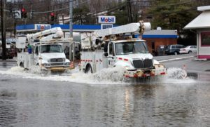 Trucks drive through a flooded road in Greenburgh, N.Y. Sunday, March 14, 2010 after a storm passed through the region. (AP Photo/Craig Ruttle)